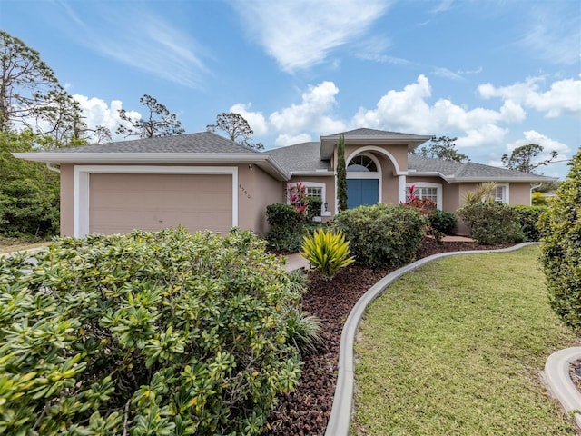 ranch-style house featuring a garage and a front lawn