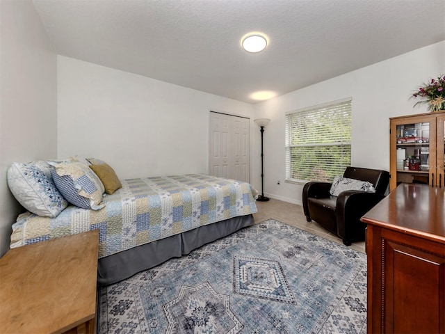 bedroom with a textured ceiling and a closet