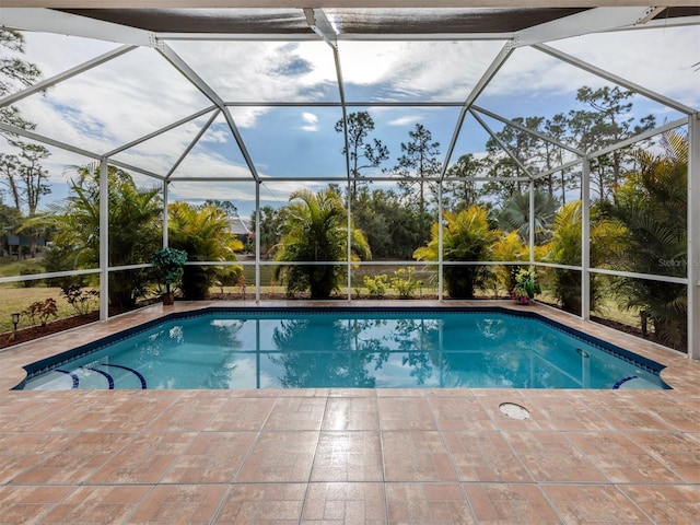 view of swimming pool with a patio and glass enclosure