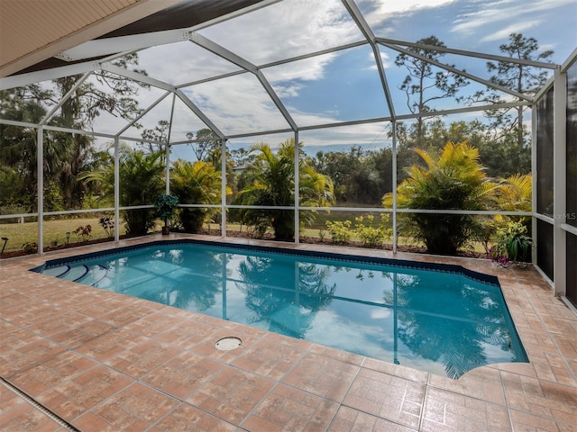 view of pool featuring glass enclosure and a patio area