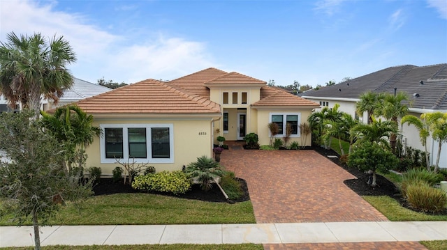 mediterranean / spanish home featuring a front lawn