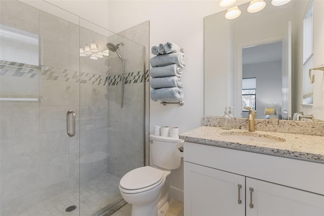 bathroom with vanity, toilet, and a shower with door