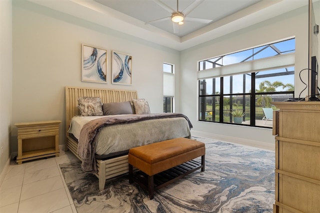 bedroom featuring a raised ceiling and ceiling fan