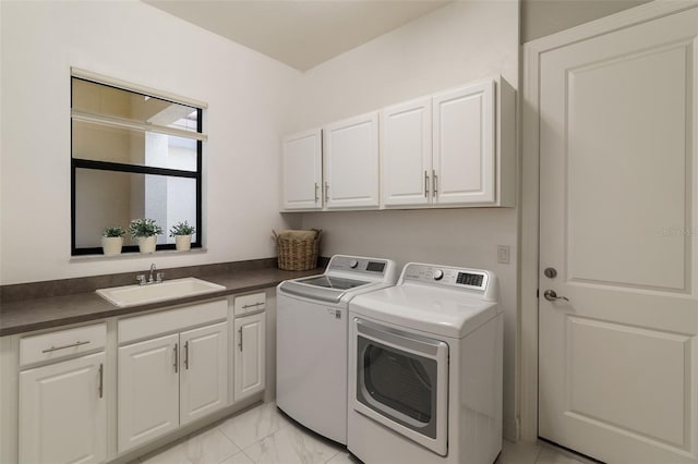 washroom with cabinets, sink, and washer and dryer