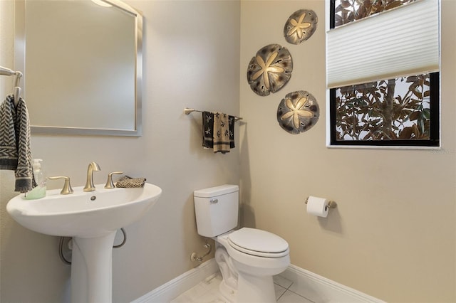 bathroom with toilet, tile patterned flooring, and sink