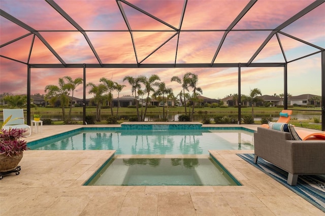 pool at dusk with an in ground hot tub, a patio, and glass enclosure