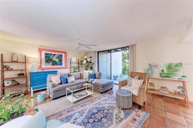 tiled living room with ceiling fan and floor to ceiling windows