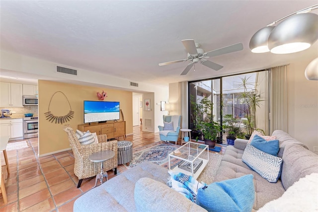 living room with light tile patterned floors, baseboards, visible vents, and ceiling fan