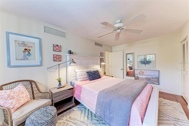 bedroom with light tile patterned floors, ceiling fan, and visible vents