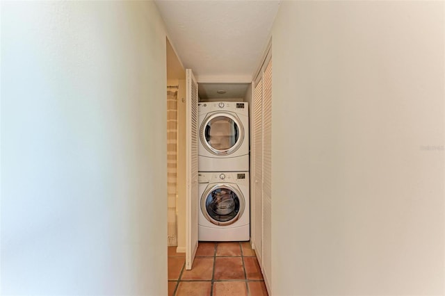 laundry room with stacked washing maching and dryer and light tile patterned floors