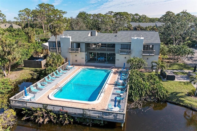 view of swimming pool with a water view and a patio area