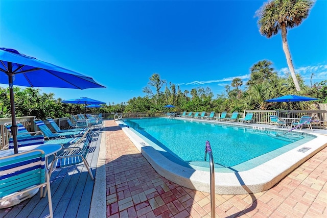 pool with a patio and fence