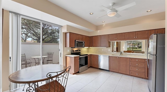 kitchen featuring ceiling fan, sink, backsplash, and appliances with stainless steel finishes