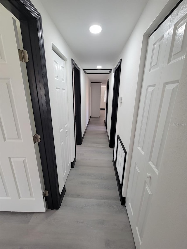 corridor with light hardwood / wood-style flooring