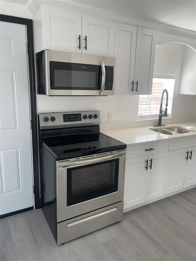 kitchen featuring light hardwood / wood-style floors, sink, white cabinets, and stainless steel appliances