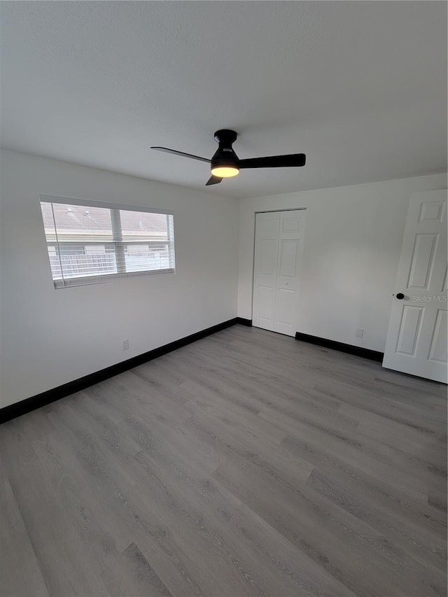 empty room with light hardwood / wood-style flooring and ceiling fan