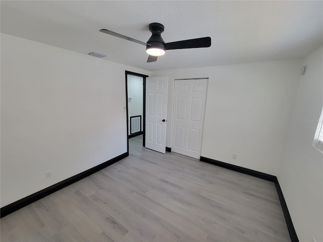 empty room with ceiling fan and light hardwood / wood-style flooring