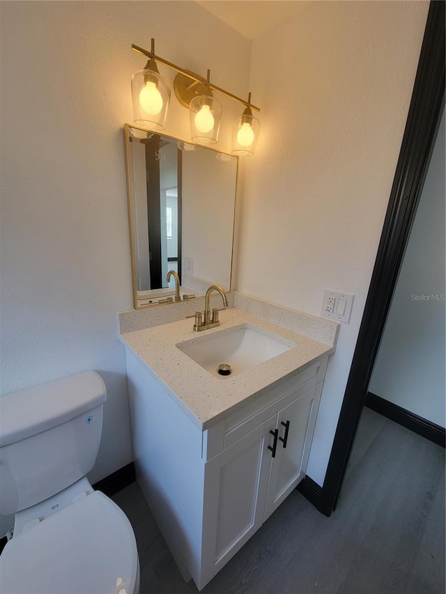 bathroom featuring hardwood / wood-style floors, toilet, and vanity