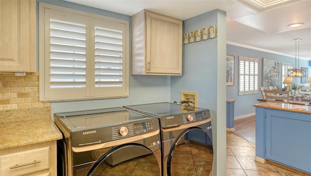 laundry room with cabinets, crown molding, washer and dryer, and light tile patterned floors