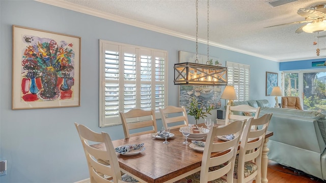 dining area with ceiling fan, crown molding, a wealth of natural light, and a textured ceiling