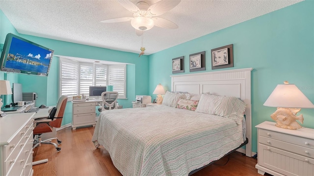 bedroom featuring ceiling fan, a textured ceiling, and light wood-type flooring