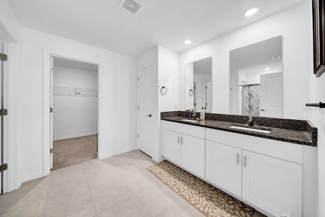 bathroom featuring curtained shower, vanity, and tile patterned flooring