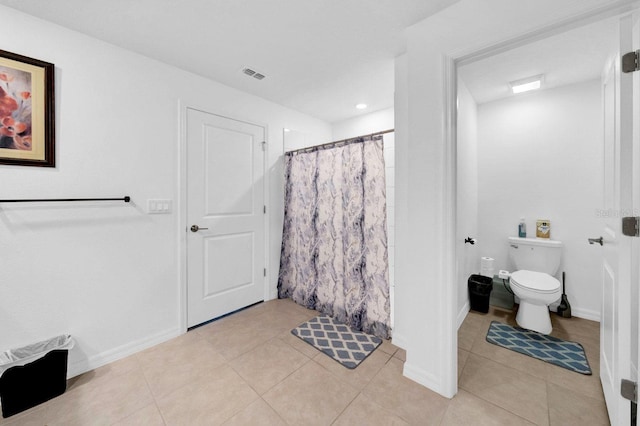 bathroom with tile patterned floors, toilet, and walk in shower