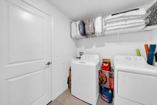 laundry area featuring light tile patterned flooring and washing machine and dryer