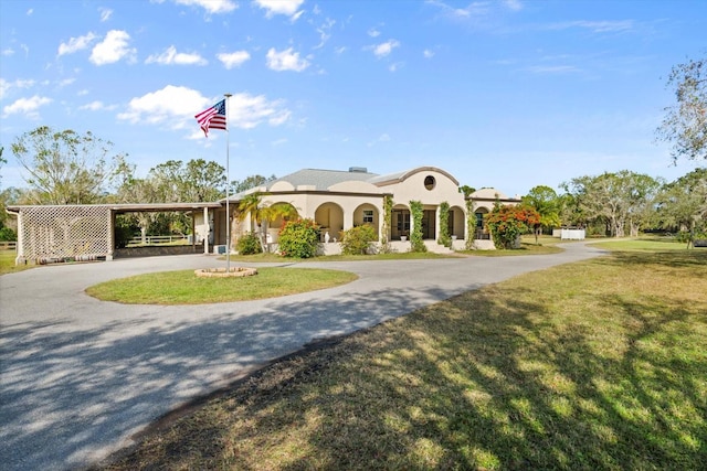 view of front of house with a carport and a front lawn