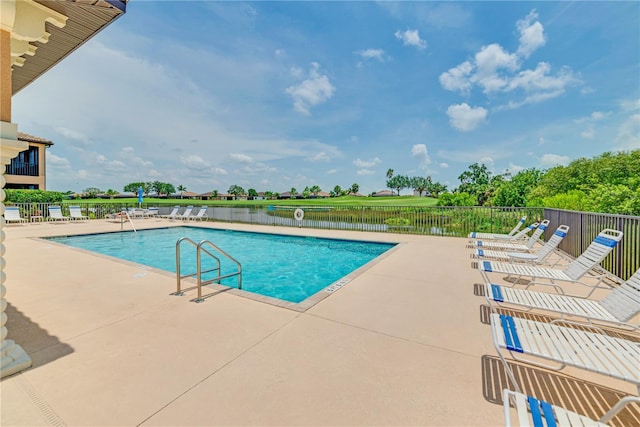 view of pool with a water view and a patio area