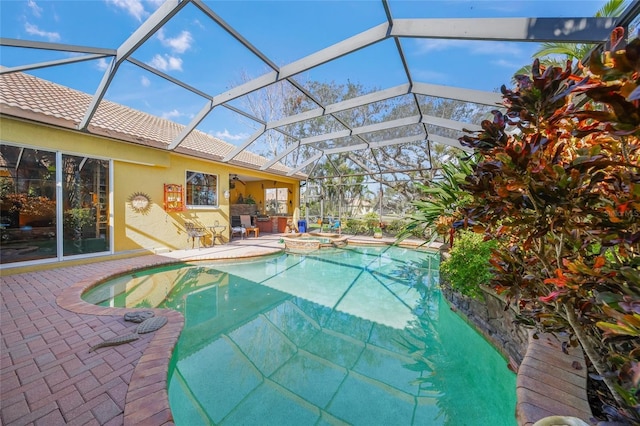 view of swimming pool featuring an in ground hot tub, a lanai, and a patio area