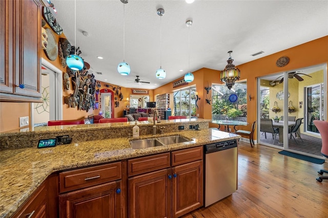 kitchen with sink, stainless steel dishwasher, a healthy amount of sunlight, and light wood-type flooring