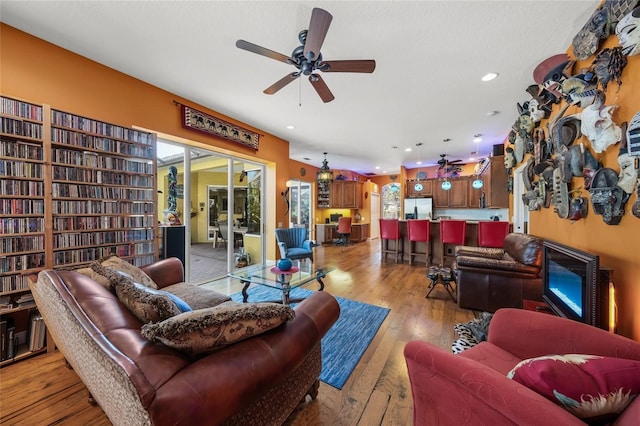 living room with ceiling fan and light wood-type flooring