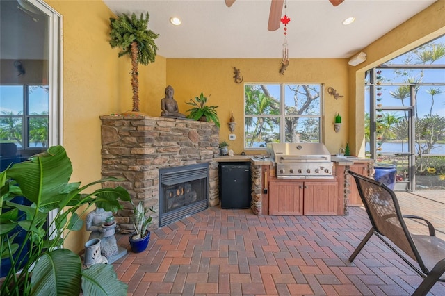 view of patio / terrace featuring a water view, area for grilling, a lanai, ceiling fan, and a grill