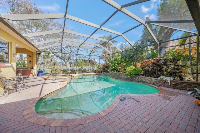 view of pool with an in ground hot tub, a patio, and glass enclosure