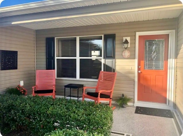 view of exterior entry featuring covered porch