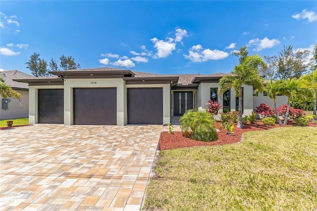 1418 SW 1st Pl, Cape Coral, FL 33991 - prairie-style house with a garage and a front lawn