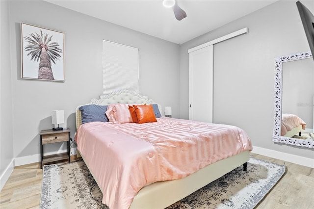 bedroom with ceiling fan, a closet, and light wood-type flooring