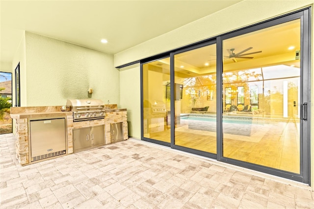 view of patio / terrace featuring grilling area, ceiling fan, and exterior kitchen