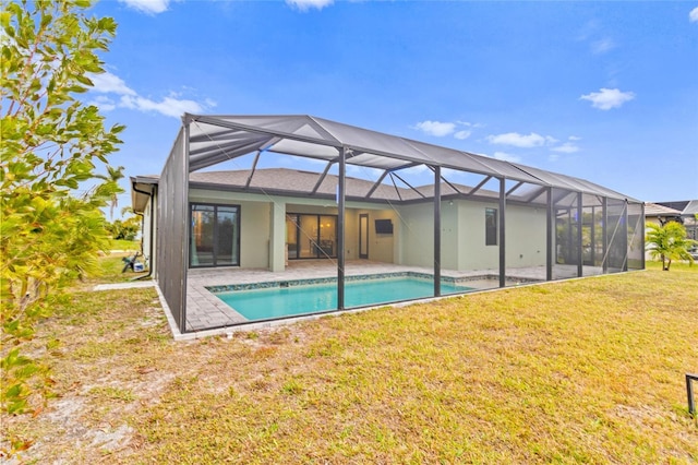 back of house featuring glass enclosure, a patio area, and a lawn