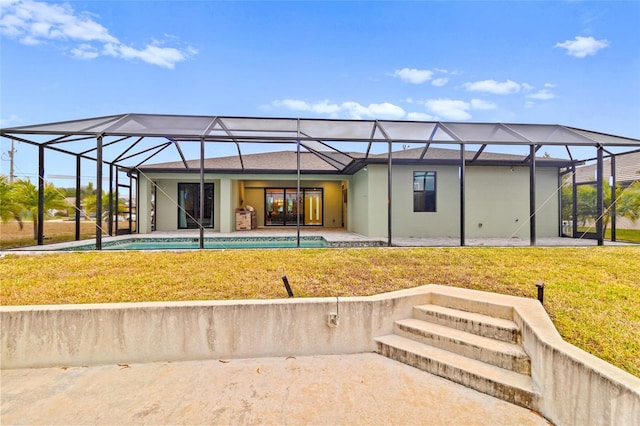 back of property with a lanai, a yard, and a patio