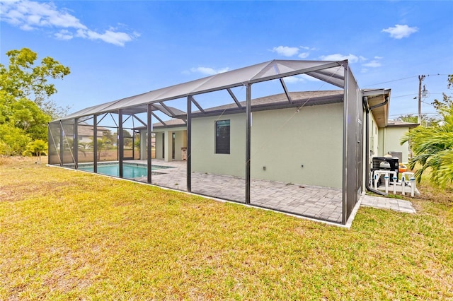 back of house featuring a lanai, a patio area, and a yard