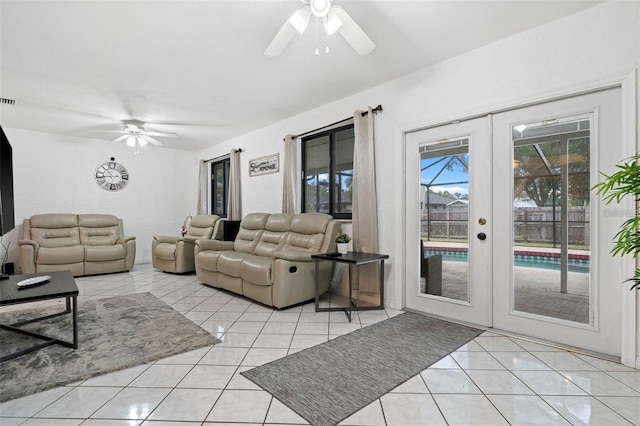 tiled living room with ceiling fan and french doors