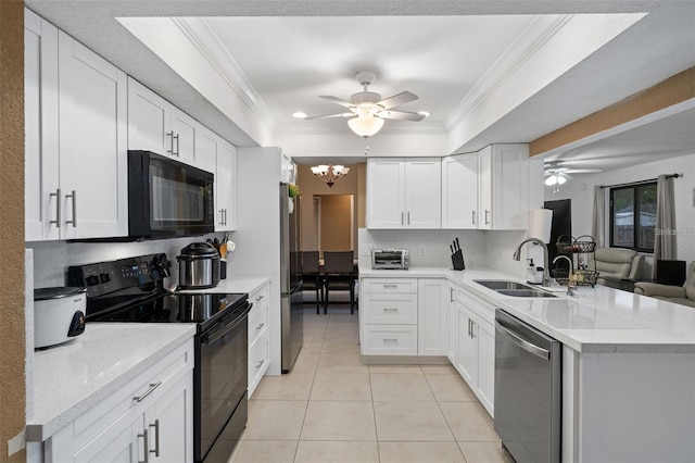 kitchen with white cabinets, black appliances, kitchen peninsula, and a raised ceiling