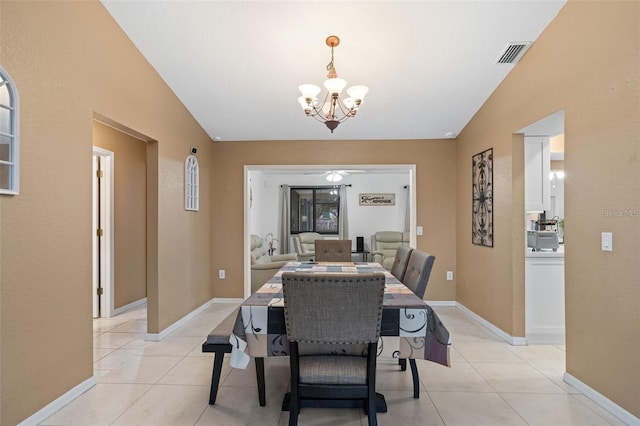 dining room featuring light tile patterned flooring, an inviting chandelier, and vaulted ceiling