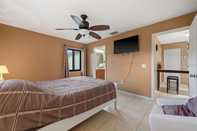 bedroom with light tile patterned floors, ensuite bath, and ceiling fan