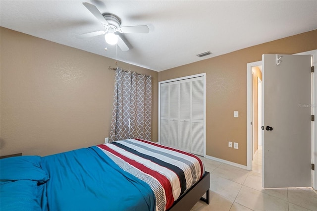 bedroom featuring light tile patterned flooring, a closet, and ceiling fan