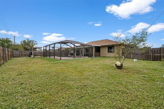 view of yard with glass enclosure and a patio