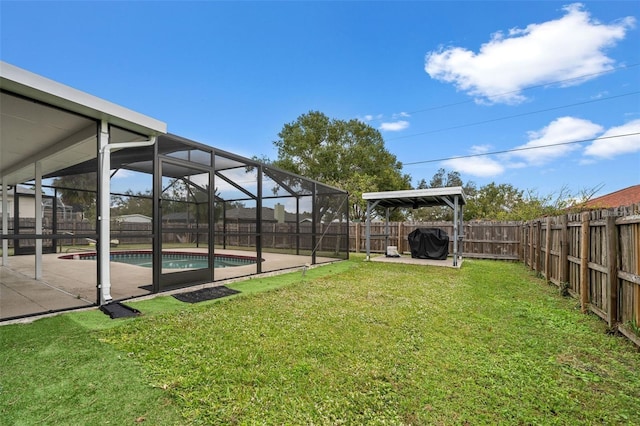 view of yard with glass enclosure, a fenced in pool, and a patio area