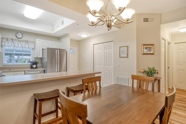 dining area featuring light hardwood / wood-style flooring and a notable chandelier